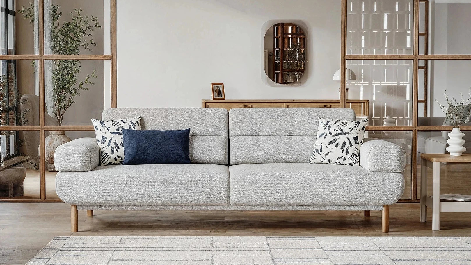 Gray sofa with decorative pillows in a modern living room setting.